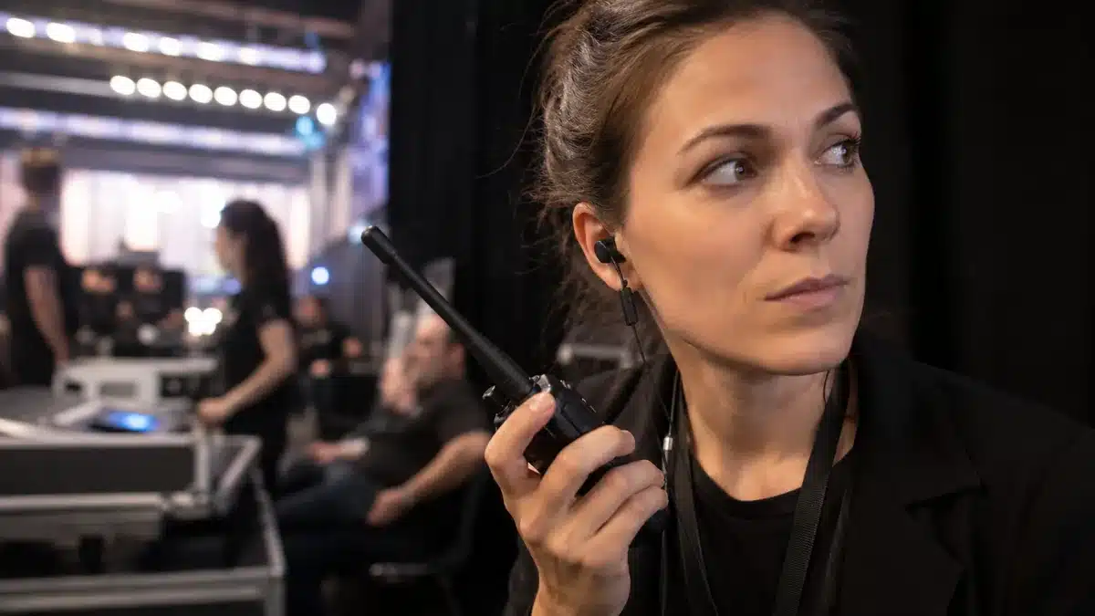 Membre d'équipe événementielle utilisant un talkie-walkie en coulisses d'un événement en Belgique